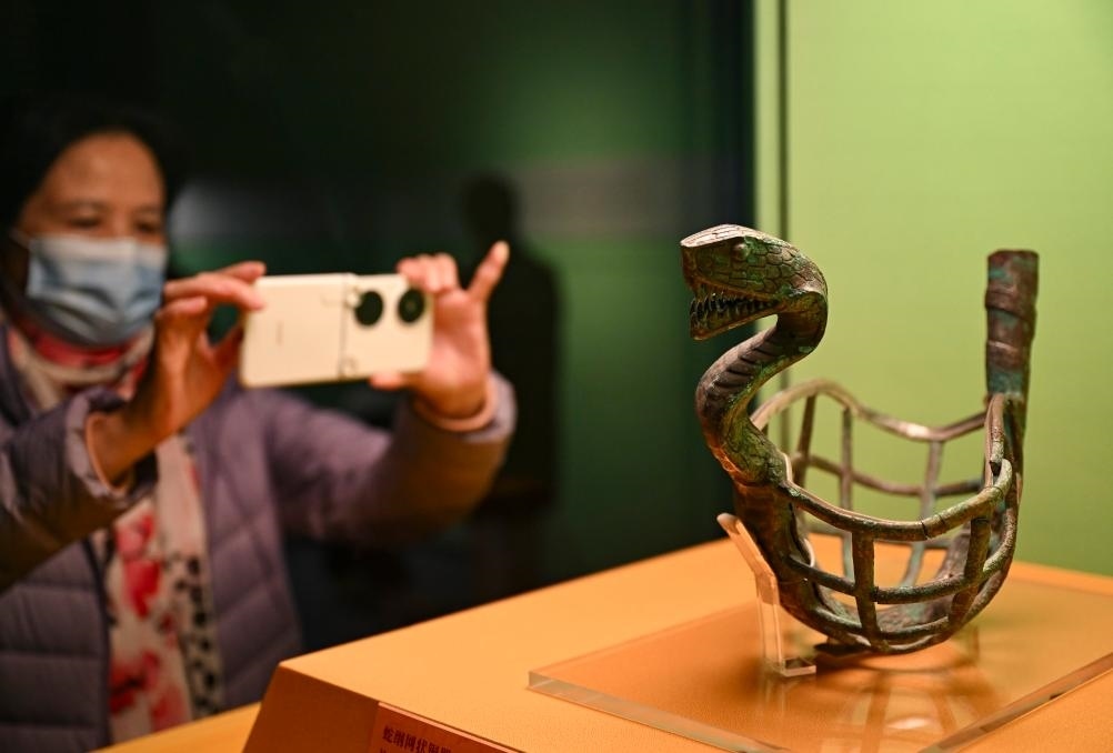 1月14日，觀眾在上海博物館蛇年迎春展拍攝展品蛇綱網(wǎng)狀銅器。新華社發(fā)（陳浩明攝）