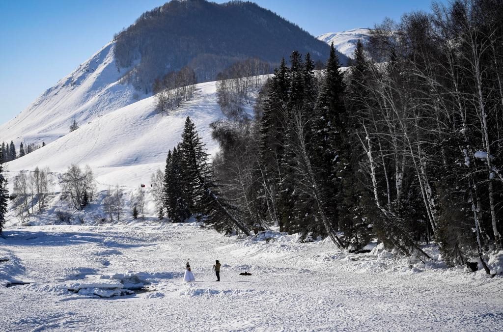 2024年2月5日，兩名游客在新疆阿勒泰地區(qū)布爾津縣禾木村拍照。新華社記者 馬鍇 攝
