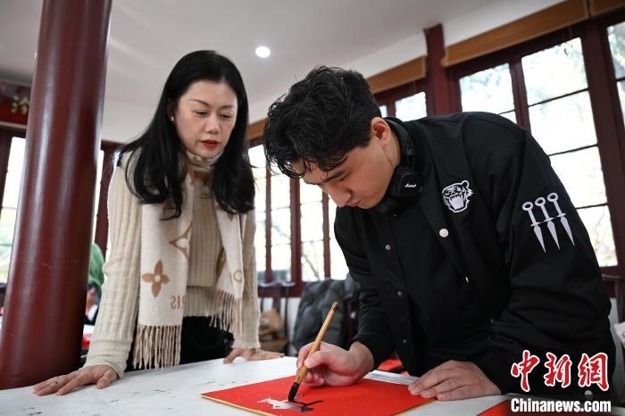 1月20日，外籍留學(xué)生在西泠印社社員李硯指導(dǎo)下寫福。當日，來自巴西、馬來西亞、加納、哈薩克斯坦的外籍留學(xué)生在浙江杭州西泠印社體驗福貼、春聯(lián)和篆刻，感受古老的中國傳統(tǒng)文化。中新社記者 王剛 攝