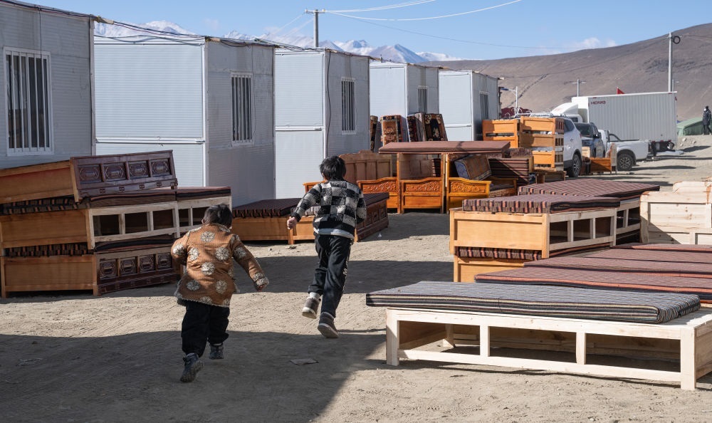 2025年1月13日，在定日縣嘎旦村，兩個孩子在剛運來的兩排藏床間奔跑。新華社記者丁增尼達(dá) 攝