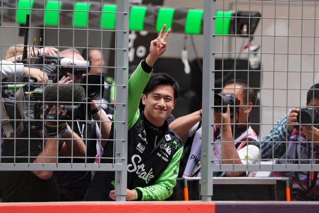 2024年4月19日，索伯車隊(duì)中國(guó)車手周冠宇（中）在練習(xí)賽前向觀眾致意。當(dāng)日，F(xiàn)1中國(guó)大獎(jiǎng)賽在上海開賽。中國(guó)車手周冠宇主場(chǎng)首秀參賽。新華社記者 夏一方攝