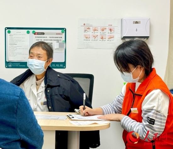 秦苑（中）接診患者。人民網(wǎng)記者 金慧慧攝