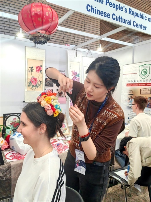 展覽正值羅馬尼亞迎春花節(jié)，國際中文教師志愿者潘婧穎向游客們介紹了國家非物質(zhì)文化遺產(chǎn)——福建泉州的簪花文化。布加勒斯特大學(xué)孔子學(xué)院供圖。