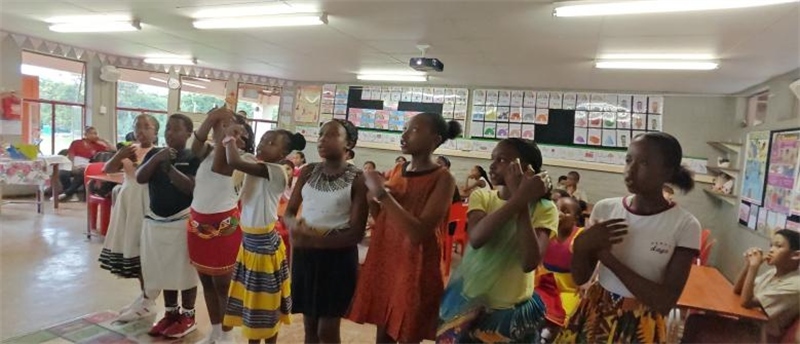 南非學(xué)生展示民族服飾，合唱《聽我說謝謝你》。