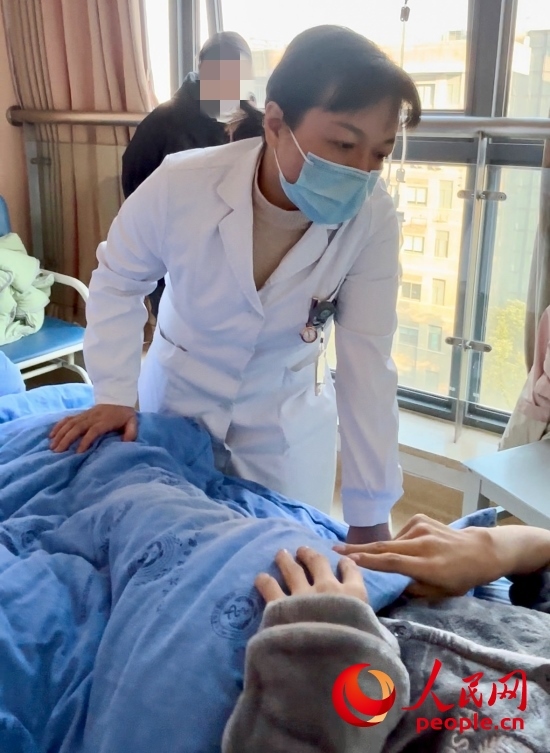 鄧茜查房時(shí)詢問患者情況。人民網(wǎng)記者 金慧慧攝