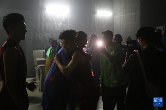 4月10日，在塞內(nèi)加爾首都達喀爾的國家大劇院，中央音樂學院進擊打擊樂團成員與塞內(nèi)加爾杜杜·恩迪亞耶·羅斯打擊樂團成員在演出后臺擁抱。新華社記者 司源 攝