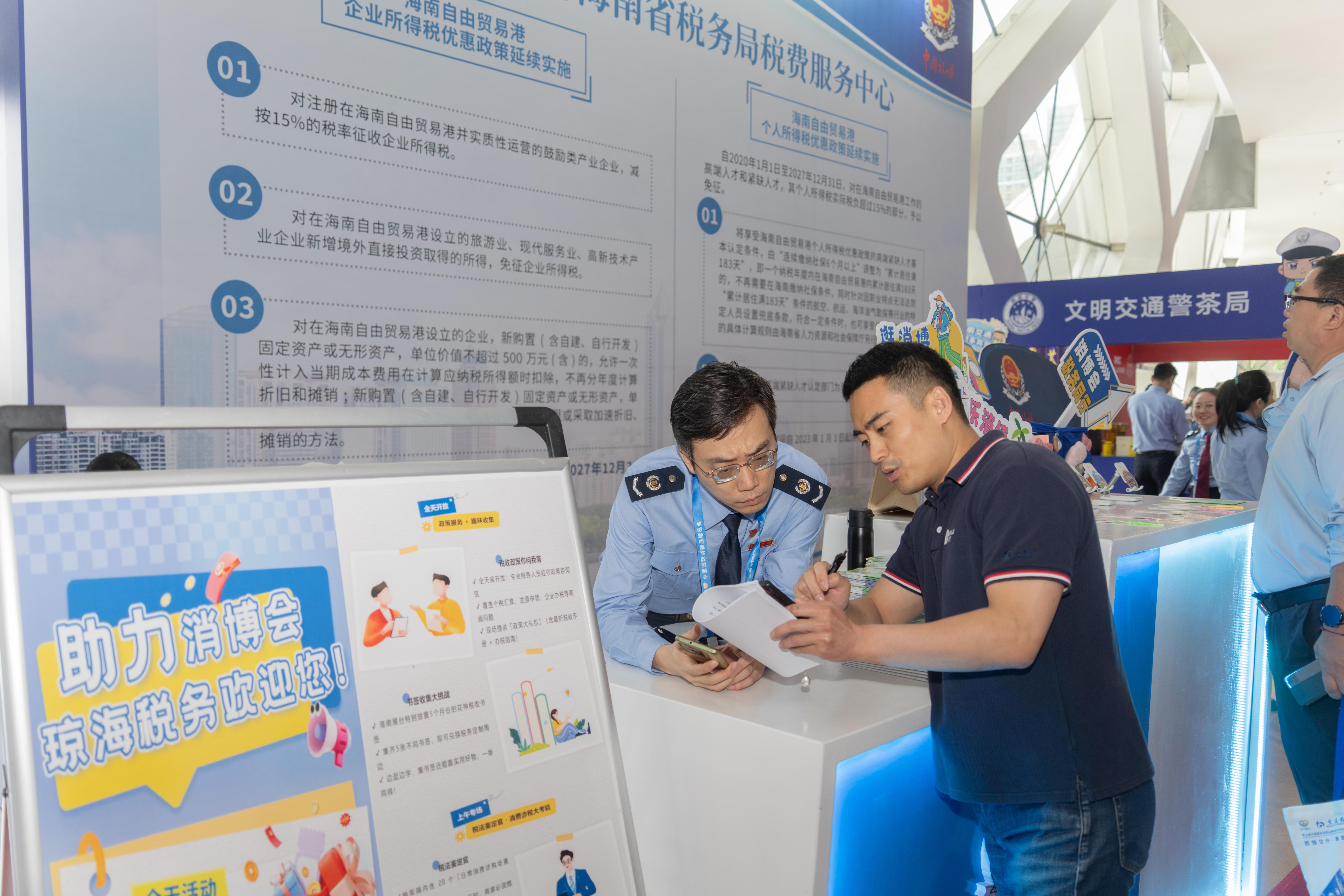 稅務(wù)服務(wù)臺工作人員向記者介紹服務(wù)參展外商的具體舉措。人民網(wǎng)記者 許崢攝