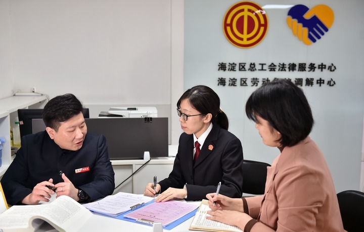 2025年3月6日，在北京市海淀區(qū)總工會勞動爭議調(diào)解中心，海淀區(qū)人民法院法官王琰（中）與該中心工作人員就糾紛化解情況進行溝通。新華社記者 趙婷婷 攝
