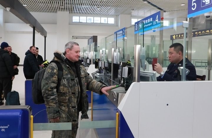 2024年12月10日，在黑河公路口岸旅檢大廳，黑河出入境邊防檢查站民警為首班次客車入境旅客辦理邊檢通關(guān)手續(xù)。當(dāng)日，中國黑河公路口岸—俄羅斯卡尼庫爾干公路口岸旅客運輸正式開通。新華社發(fā)（劉松攝）