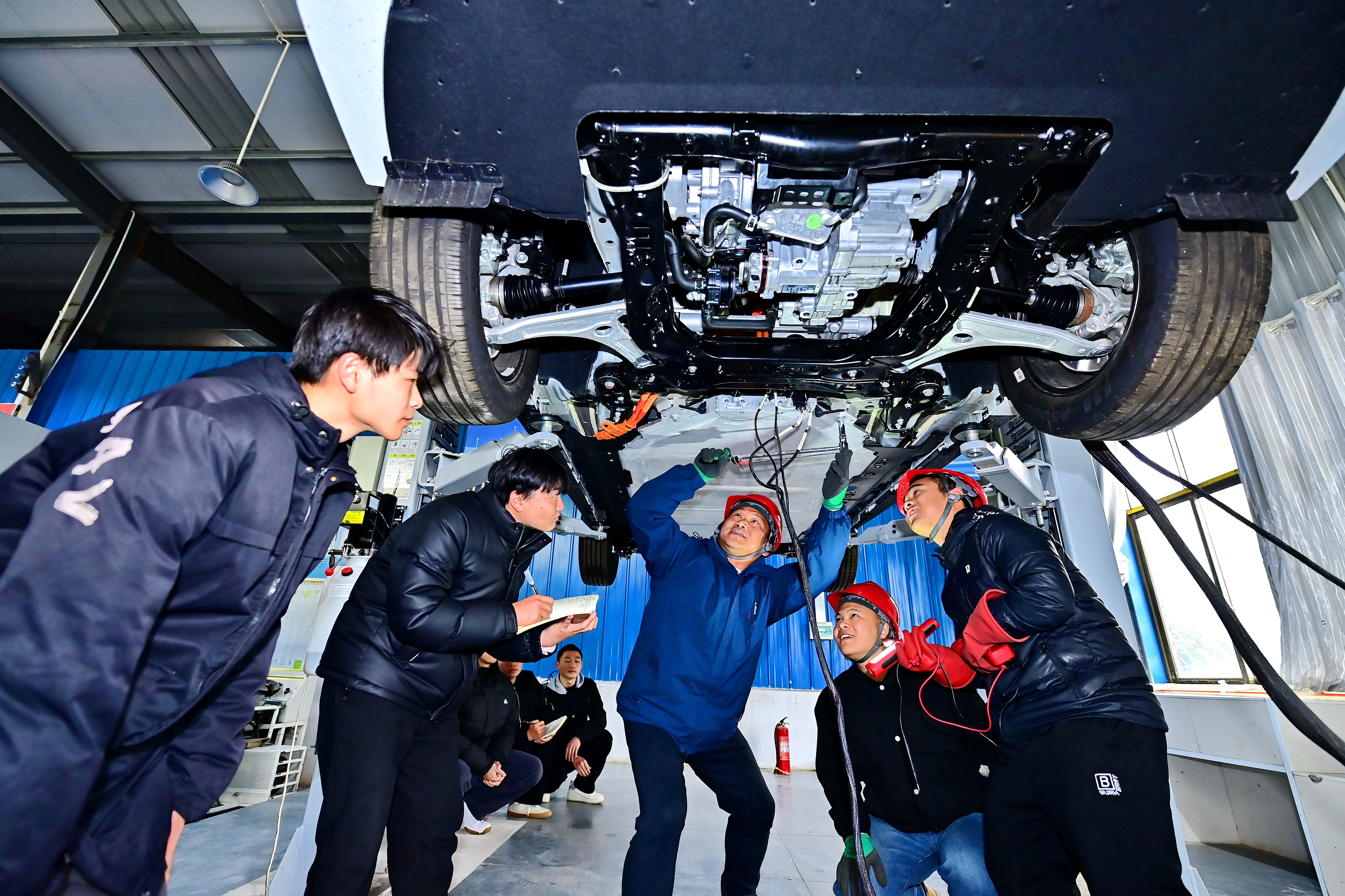 2025年2月，江西省宜春市，豐城市的一所技工學(xué)校實(shí)訓(xùn)基地內(nèi)，新能源汽車運(yùn)維專業(yè)學(xué)生在老師的指導(dǎo)下學(xué)習(xí)新能源汽車電池包檢修技術(shù)。