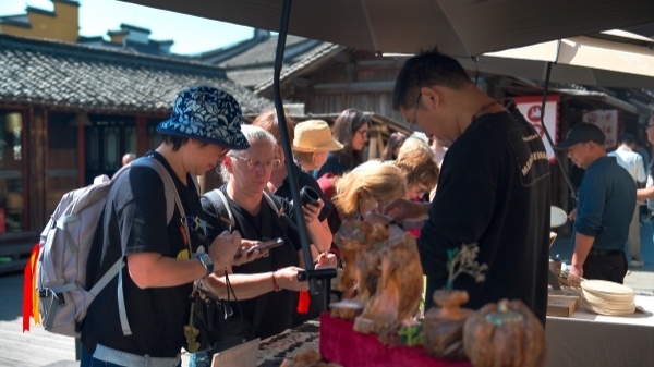 “五一”期間，游客正在烏鎮(zhèn)“水鄉(xiāng)碼頭”挑選購買文創(chuàng)產(chǎn)品。受訪者供圖