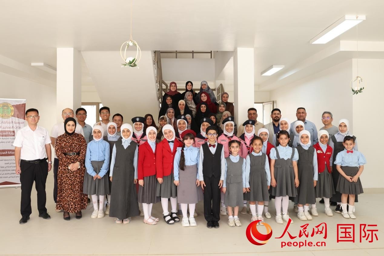 中國電建員工與阿爾穆塔?阿里卡特國際學(xué)校的師生及政府官員等合影。人民網(wǎng)記者 薛丹攝