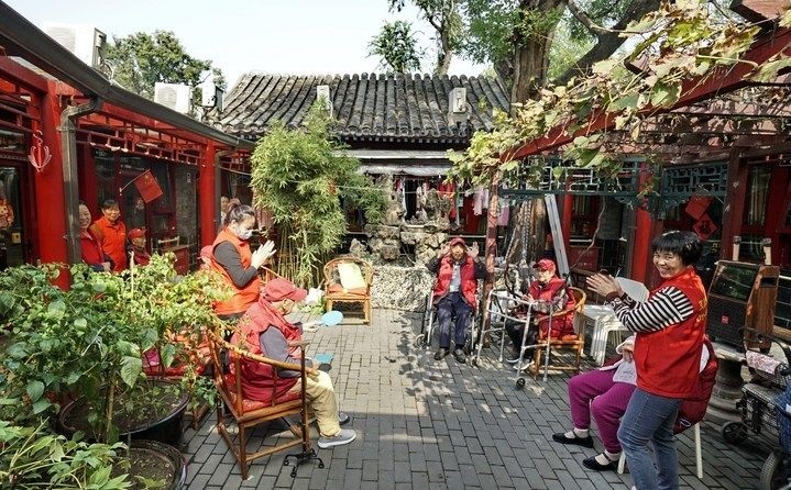 2024年10月12日，鐘樓灣胡同的老年人在社區(qū)內(nèi)的四合院養(yǎng)老驛站休閑。2017年起，北京市先后開展了兩輪背街小巷環(huán)境整治提升行動，完整保留了中軸線生活建筑群的歷史信息，并根據(jù)居民的生活和居住方式進行適配化的更新和改造，極大地改善了生活環(huán)境。2023年鐘樓灣胡同被評為“北京最美街巷”。