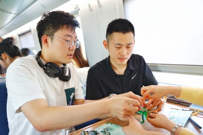 G232次旅客親手制作端午荷包和五彩繩。王磊攝