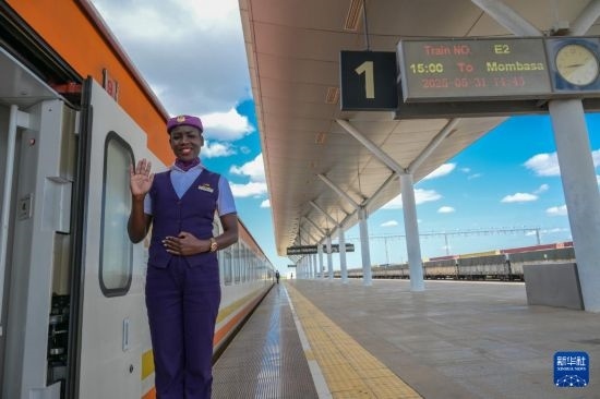 5月31日，在蒙內(nèi)鐵路內(nèi)羅畢站，一名乘務(wù)員在即將開(kāi)往蒙巴薩的E2次列車(chē)旁等候乘客。新華社記者 楊光 攝