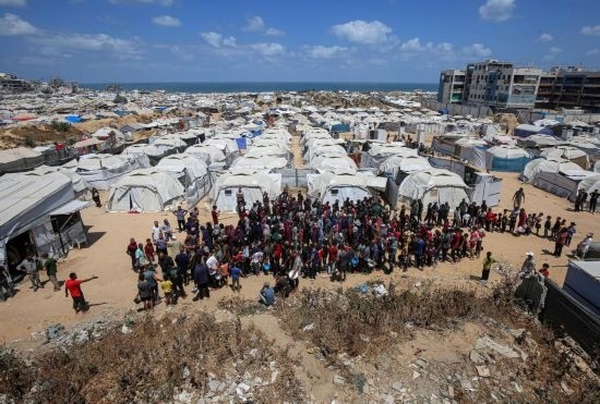 5月28日，人們在加沙城西部的沙提難民營等待領取救助食物。新華社發(fā)（里澤克·阿卜杜勒賈瓦德攝）
