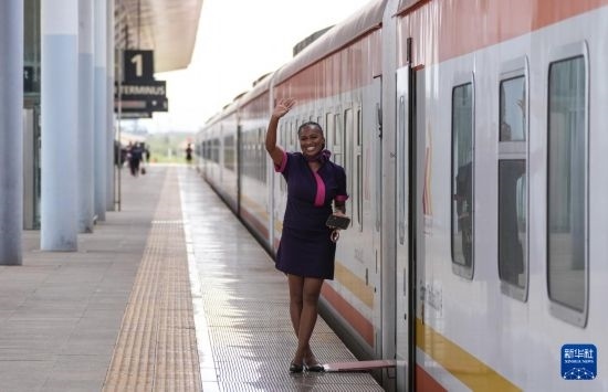 5月31日，在蒙內(nèi)鐵路內(nèi)羅畢站，一名乘務(wù)員在即將開(kāi)往蒙巴薩的E2次列車(chē)旁等候乘客。新華社記者 李亞輝 攝
