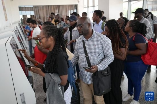 5月31日，在蒙內(nèi)鐵路內(nèi)羅畢站，乘客在自助取票機(jī)前排隊(duì)取票。新華社記者 楊光 攝