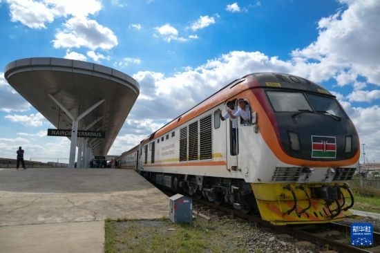 5月31日，在蒙內(nèi)鐵路內(nèi)羅畢站，機(jī)車(chē)駕駛員蔣立平（右）和博爾在即將開(kāi)往蒙巴薩的E2次列車(chē)上揮手致意。新華社記者 楊光 攝