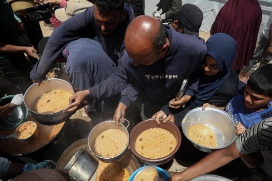 5月28日，人們在加沙城西部的沙提難民營領取救助食物。新華社發(fā)（里澤克·阿卜杜勒賈瓦德攝）