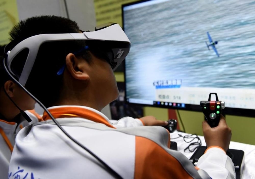 北京市八一學(xué)校的學(xué)生在北京市中小學(xué)生特色科技活動(dòng)展示上體驗(yàn)VR技術(shù)（2018年11月24日攝）新華社記者 羅曉光 攝。